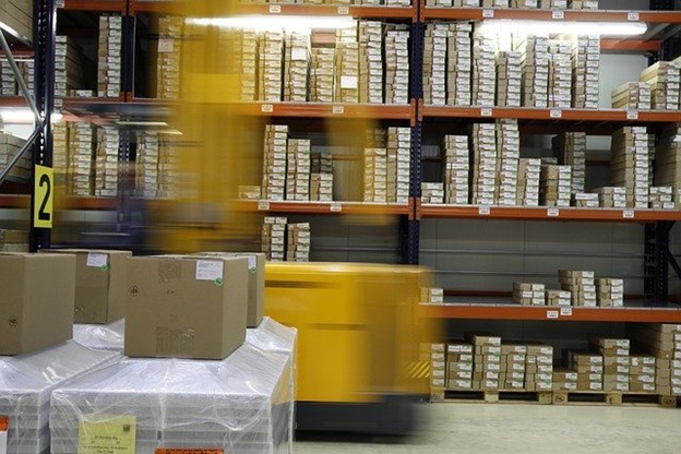 Warehouse with arranged parcels and moving forklift
