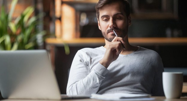 Entrepreneur thinking about online business ideas for 2025 in front of a laptop
